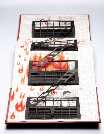 An accordion pop-up book with a person running down a fire escape