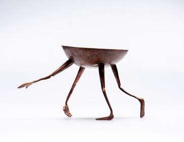 A hammered copper bowl with hand forged arms and legs. The arms and legs were then riveted to the bowl